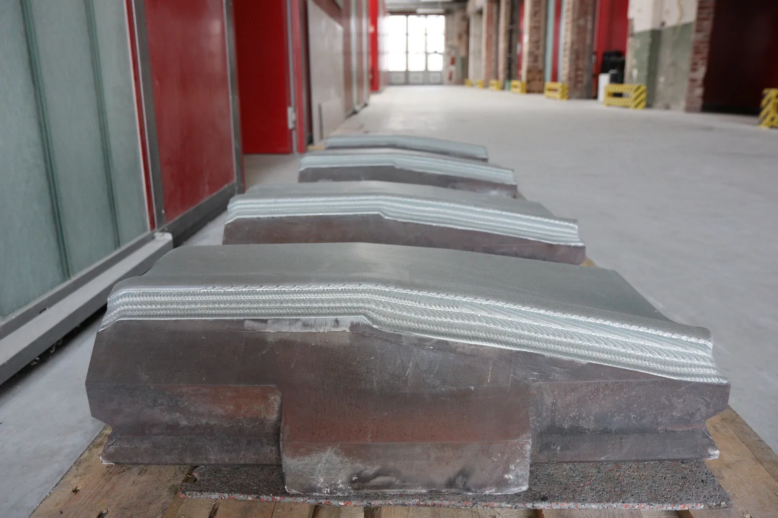 Side view of forging hammers showing incremental LMD layers on the working surface